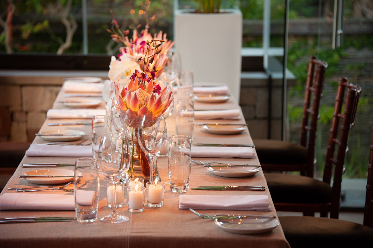 Sophisticated dining table setting featuring floral centerpieces and glassware, perfect for an elegant occasion.