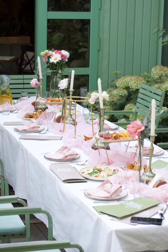 Charming garden dining setup with floral decor and pastel colors for an elegant gathering.