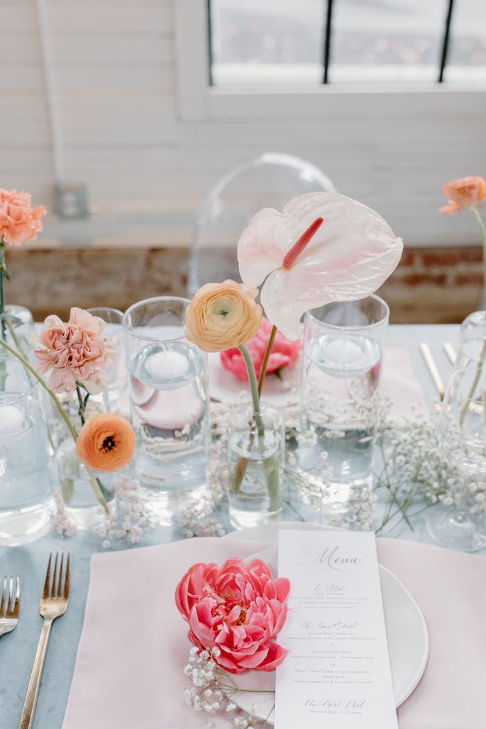 A sophisticated table arrangement with pink flowers and elegant dining setup, perfect for a wedding reception.
